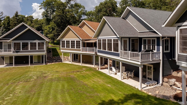 rear view of house with a lawn, a sunroom, and a patio