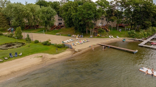 view of dock with a lawn, a water view, and a playground