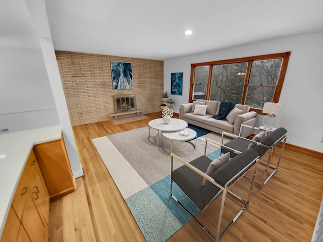 living room with a brick fireplace and wood-type flooring