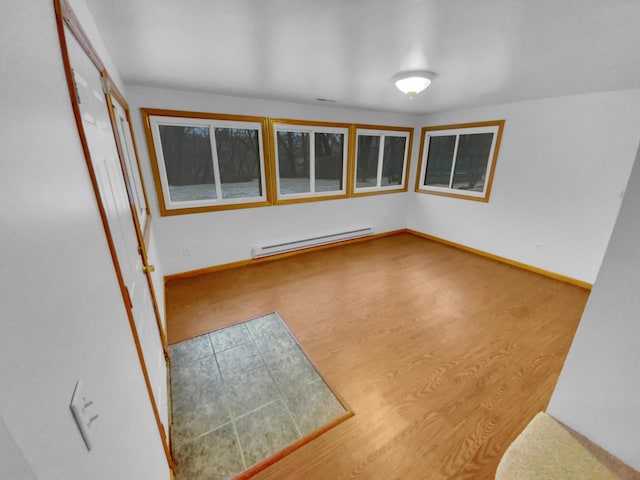 empty room featuring a baseboard radiator and hardwood / wood-style floors