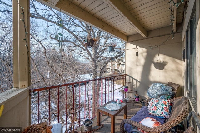 view of snow covered back of property