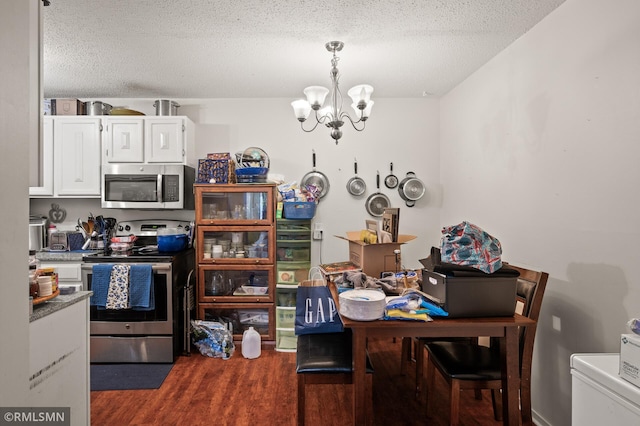 dining room featuring washer / dryer, a textured ceiling, a chandelier, and dark hardwood / wood-style floors