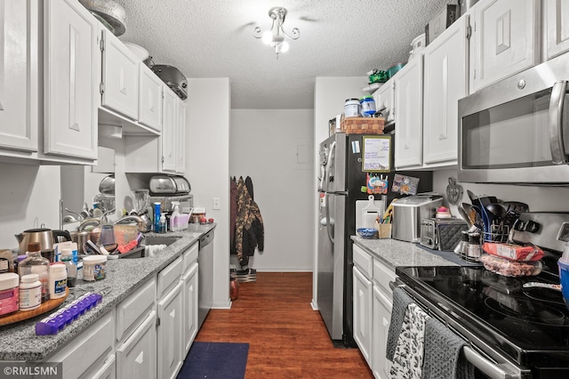 kitchen with white cabinetry, dark wood-type flooring, a textured ceiling, and stainless steel appliances