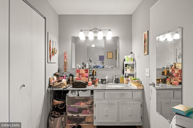 bathroom with a textured ceiling and vanity