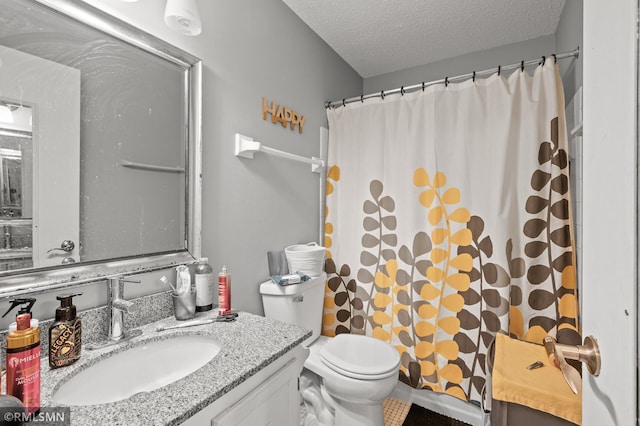 bathroom featuring toilet, a textured ceiling, and vanity