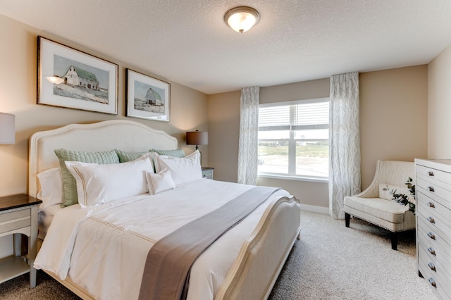 bedroom with light colored carpet and a textured ceiling