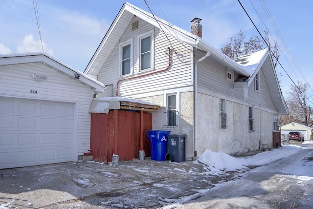 snow covered property with a garage