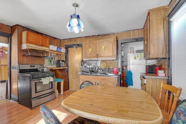 kitchen with tasteful backsplash, sink, extractor fan, light hardwood / wood-style flooring, and stainless steel gas range oven