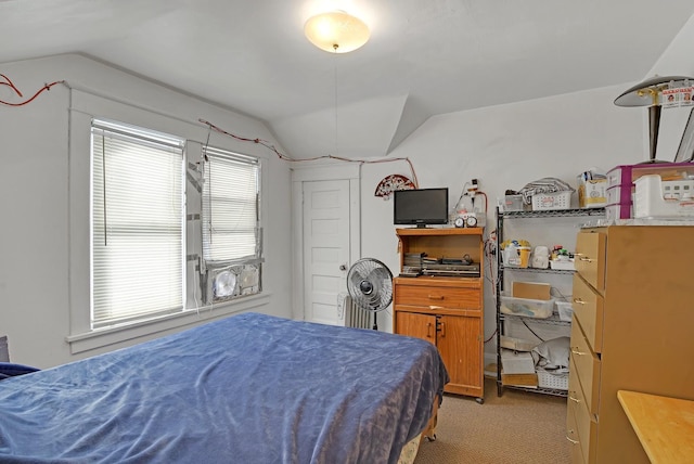 bedroom with lofted ceiling, light carpet, and multiple windows