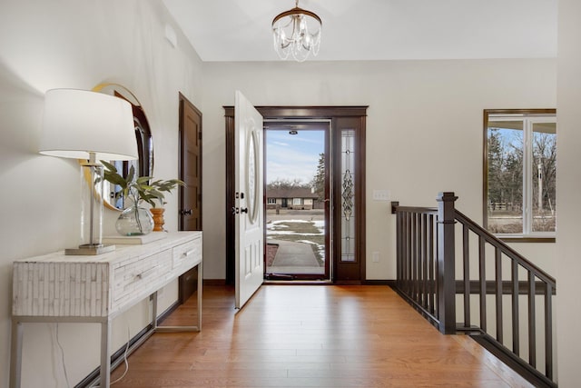 entryway with light hardwood / wood-style flooring and an inviting chandelier