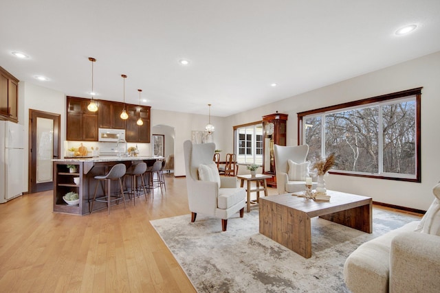 living room with light hardwood / wood-style floors and an inviting chandelier