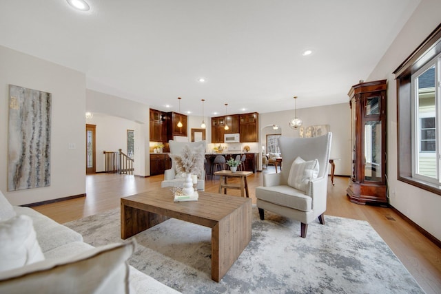 living room featuring a chandelier and light wood-type flooring