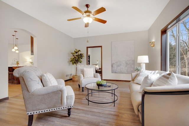 living room with light hardwood / wood-style floors and ceiling fan