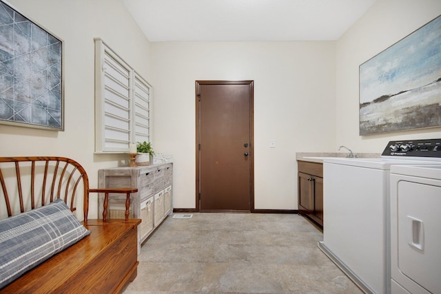 laundry room with cabinets, sink, and washing machine and clothes dryer