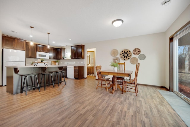 dining space with light wood-type flooring and a wealth of natural light