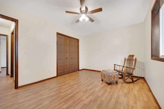 living area featuring light wood-type flooring and ceiling fan