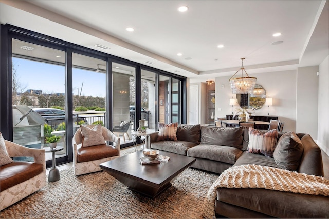 living room featuring a notable chandelier and a tray ceiling