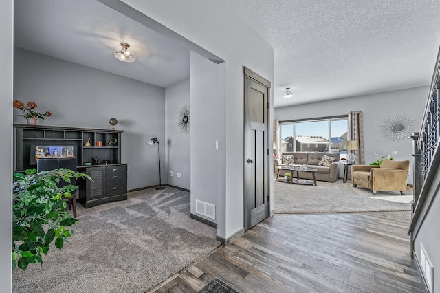 foyer entrance featuring a textured ceiling and wood-type flooring