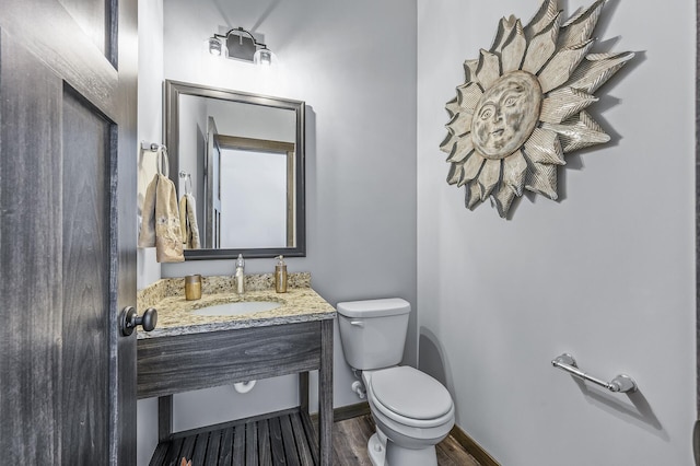 bathroom with toilet, vanity, and hardwood / wood-style flooring