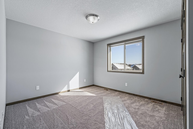 carpeted spare room with a textured ceiling