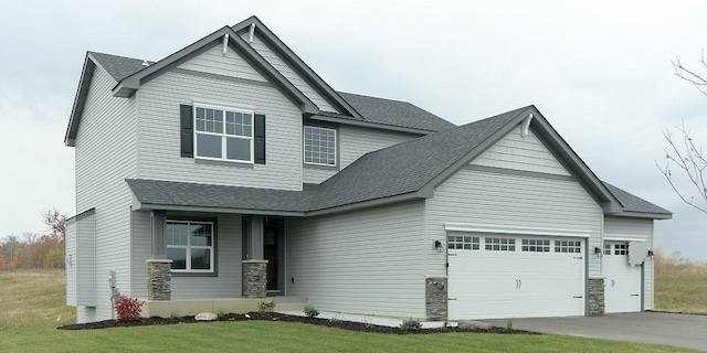 craftsman house featuring a front lawn and a garage