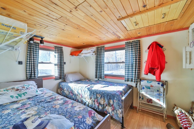 bedroom featuring hardwood / wood-style floors, multiple windows, and wooden ceiling