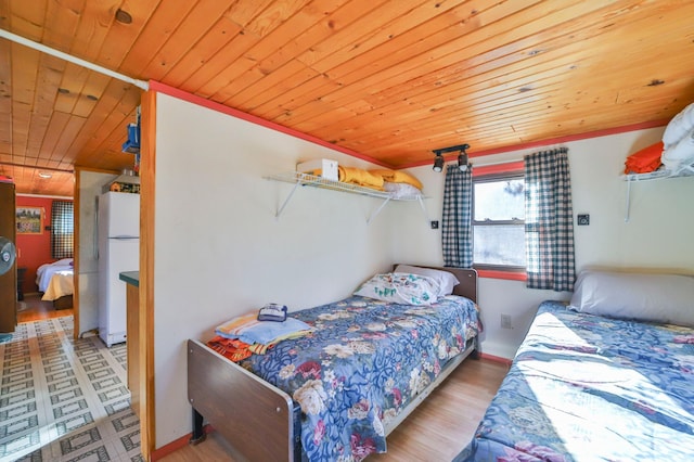 bedroom featuring light hardwood / wood-style floors, white fridge, and wooden ceiling