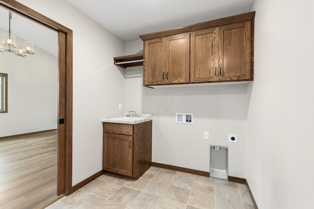 washroom with sink, cabinets, a chandelier, hookup for a washing machine, and electric dryer hookup