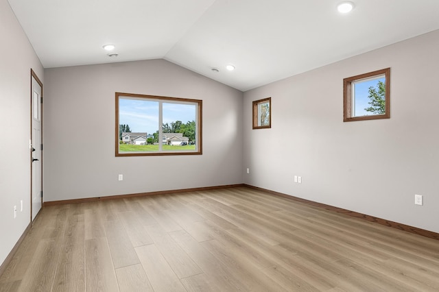 unfurnished room featuring vaulted ceiling and light wood-type flooring