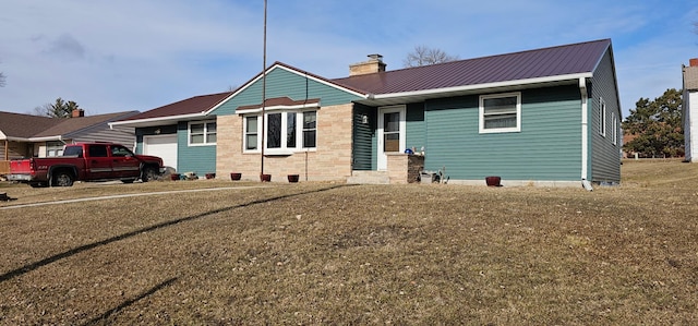 view of front of home featuring a chimney, a garage, and metal roof