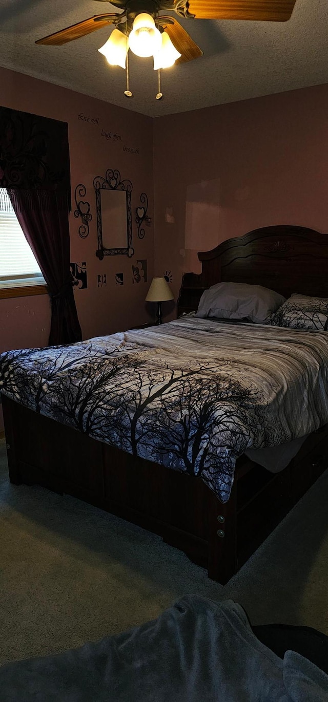 carpeted bedroom with a textured ceiling and ceiling fan