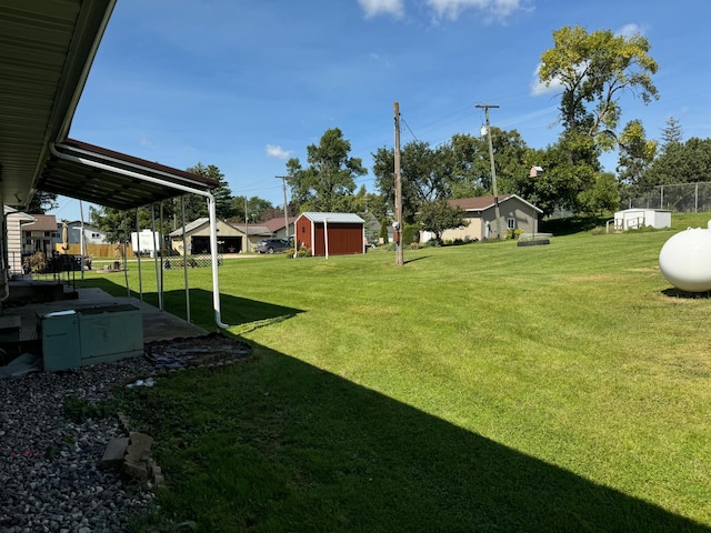 view of yard with a storage shed, an outbuilding, and fence