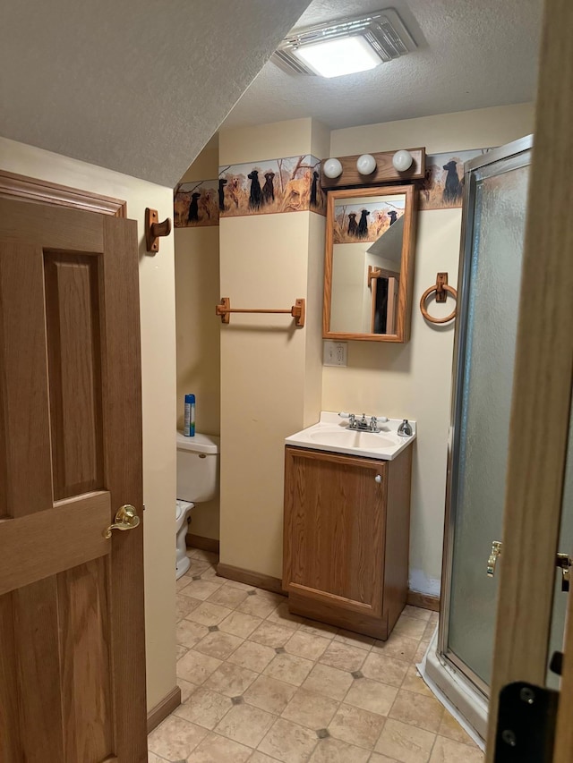 bathroom with visible vents, toilet, a textured ceiling, a shower stall, and vanity