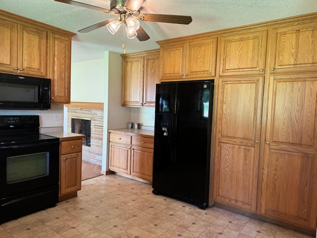 kitchen with a textured ceiling, light floors, black appliances, and light countertops