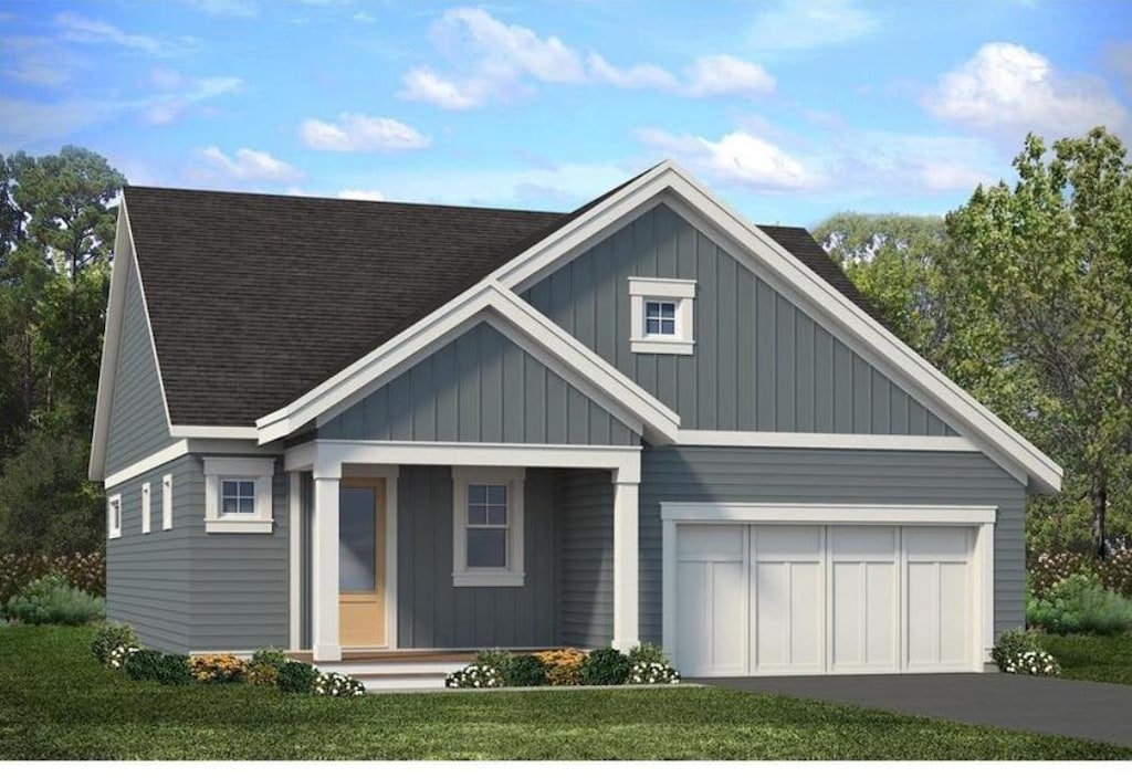 view of front of house featuring a front lawn, covered porch, and a garage