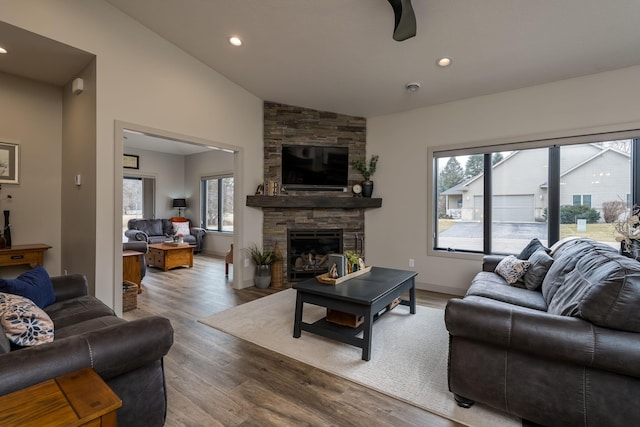 living room featuring hardwood / wood-style flooring, lofted ceiling, and a fireplace