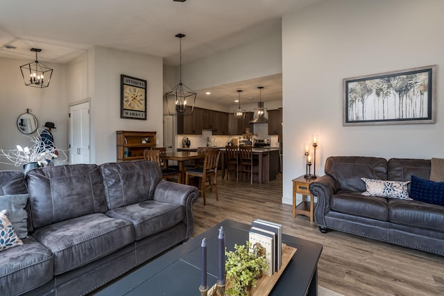 living room featuring wood-type flooring and a notable chandelier