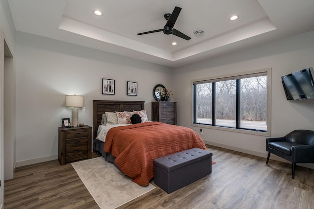 bedroom featuring ceiling fan, a tray ceiling, and hardwood / wood-style floors