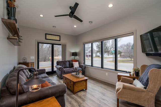 living room featuring ceiling fan and light hardwood / wood-style flooring