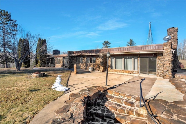 rear view of property featuring a yard and a patio area