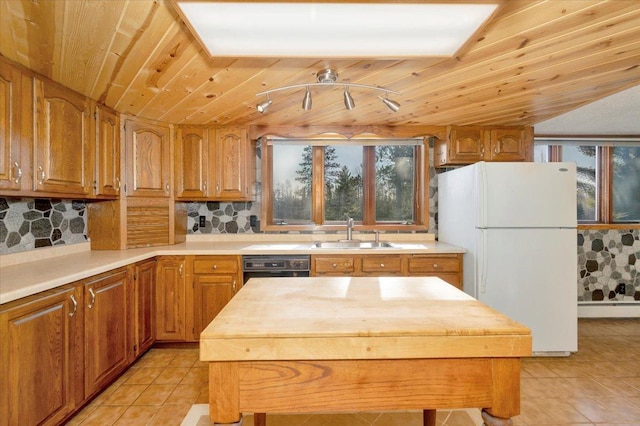 kitchen featuring sink, tasteful backsplash, light tile patterned floors, white refrigerator, and wooden ceiling