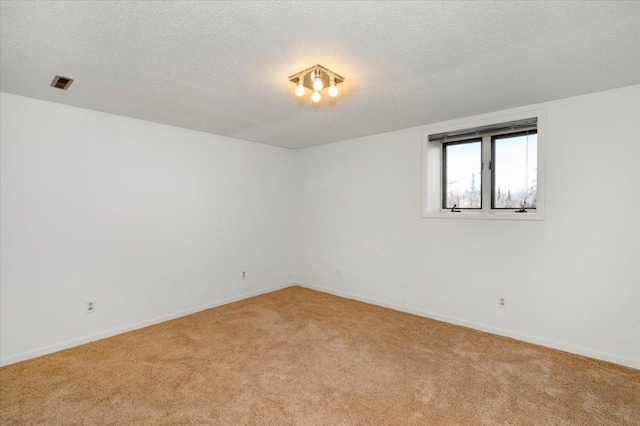 carpeted empty room featuring a textured ceiling