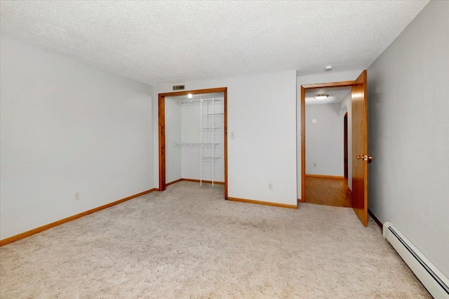 unfurnished bedroom with light carpet, a closet, a textured ceiling, and baseboard heating