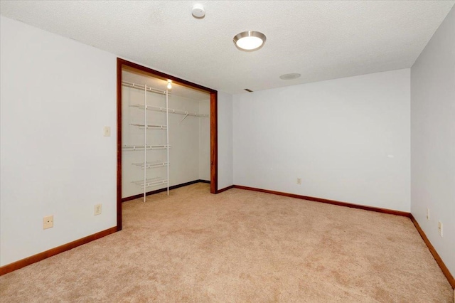 unfurnished bedroom with light carpet, a closet, and a textured ceiling