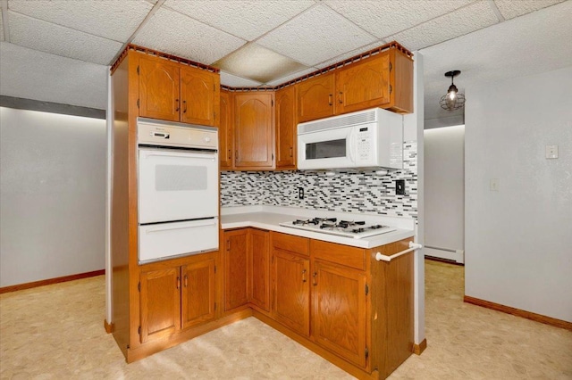 kitchen featuring a paneled ceiling, backsplash, white appliances, and baseboard heating