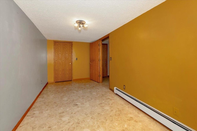 empty room with a baseboard heating unit and a textured ceiling