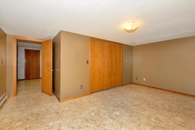 unfurnished bedroom with a closet, light colored carpet, a textured ceiling, and a baseboard heating unit