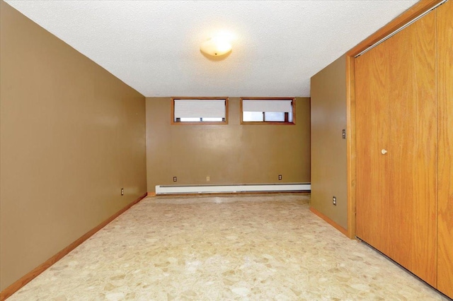 empty room with a baseboard radiator, light carpet, and a textured ceiling