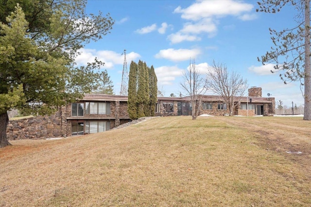 rear view of house featuring a lawn