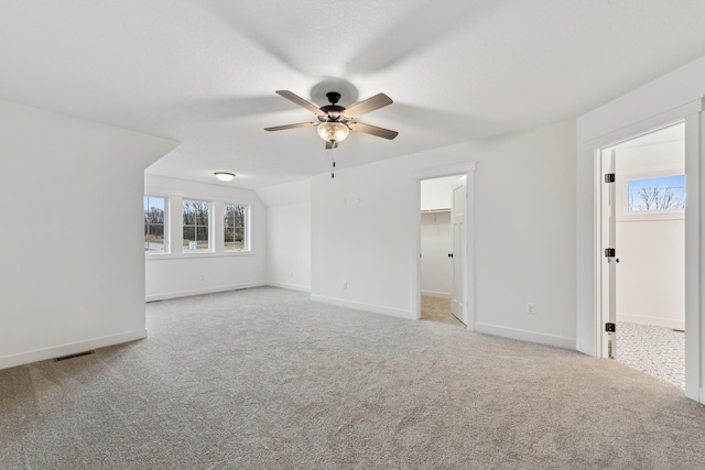 spare room with lofted ceiling, ceiling fan, and light colored carpet